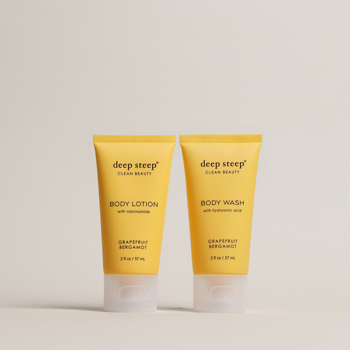 Two tubes of Deep Steep Grapefruit Bergamot Body Lotion and Body Wash, 2 fl oz tubes, on a beige background