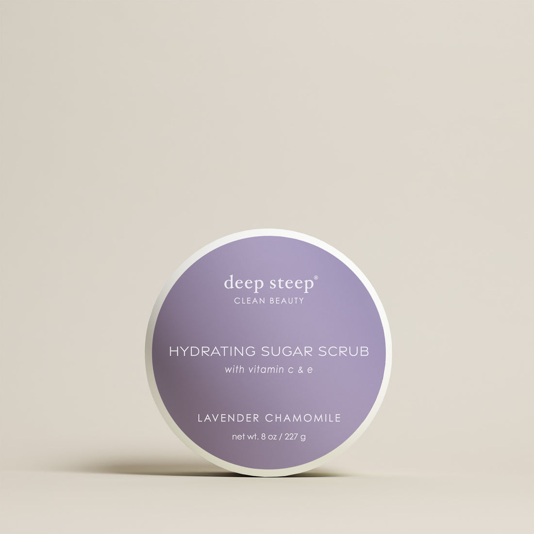 8 oz / 227 g Deep Steep Lavender Chamomile hydrating sugar scrub with vitamin C and E in a container on a beige background