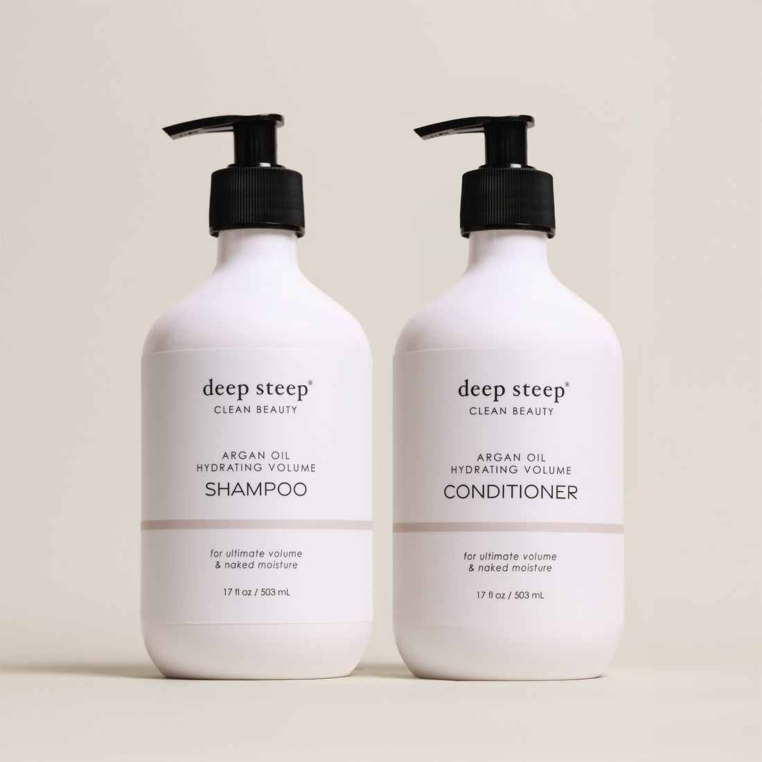 Two bottles of Deep Steep Argan Oil Hydrating Volume Shampoo and Conditioner, 17 fl oz bottles with pumps, on a beige background