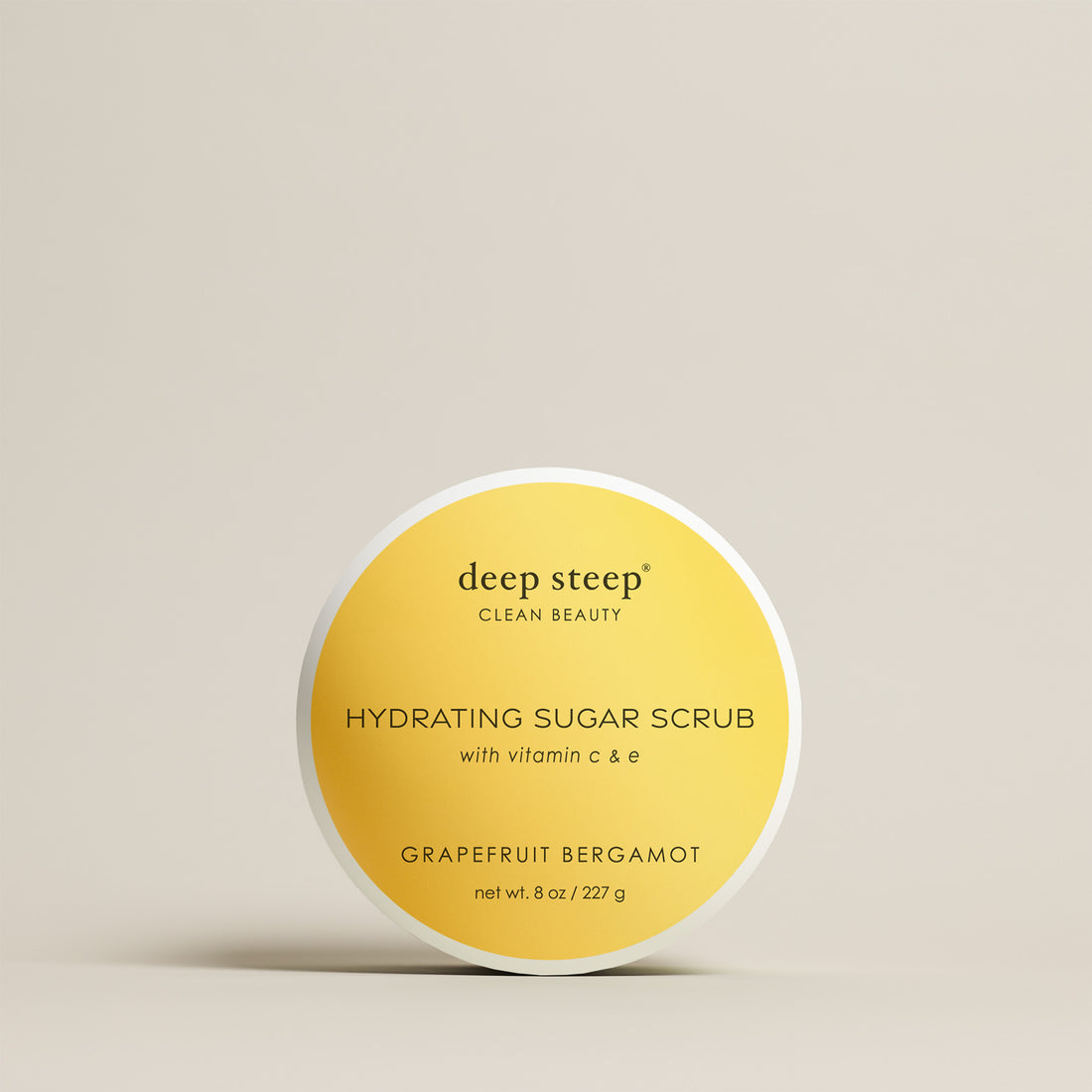8 oz / 227 g Deep Steep Grapefruit Bergamot hydrating sugar scrub with vitamin C and E in a container on a beige background
