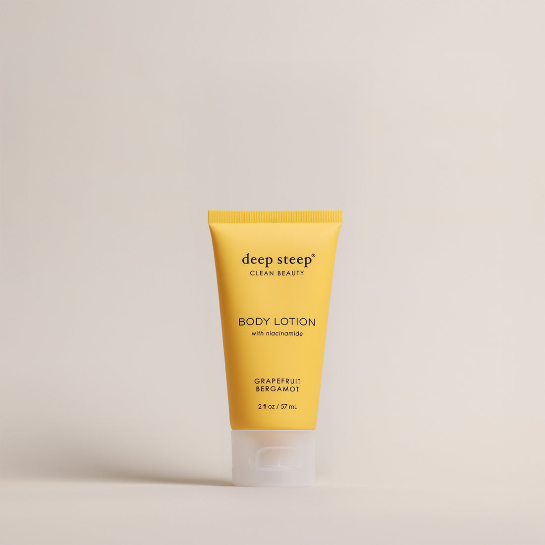 Deep Steep Grapefruit Bergamot Body Lotion, 2 fl oz tube, featuring niacinamide on a beige background