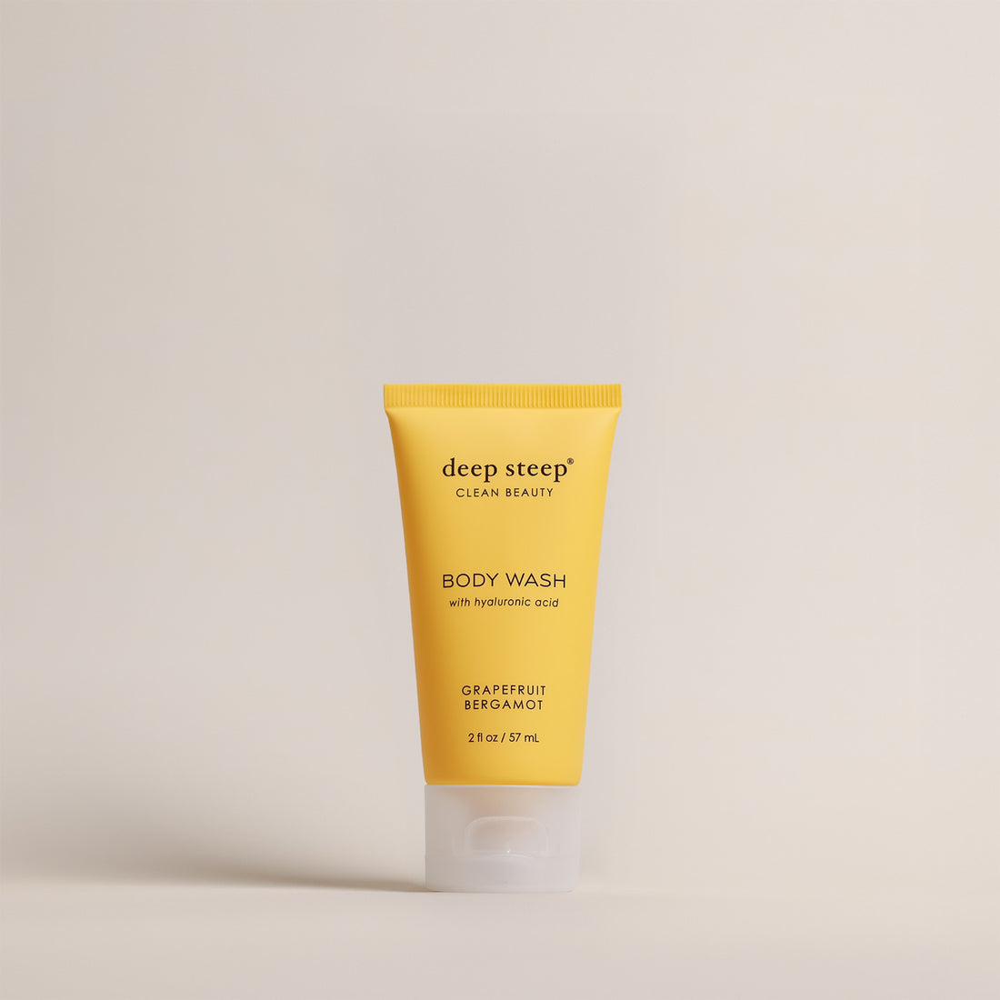 Deep Steep Grapefruit Bergamot Body Wash, 2 fl oz tube, featuring hyaluronic acid on a beige background
