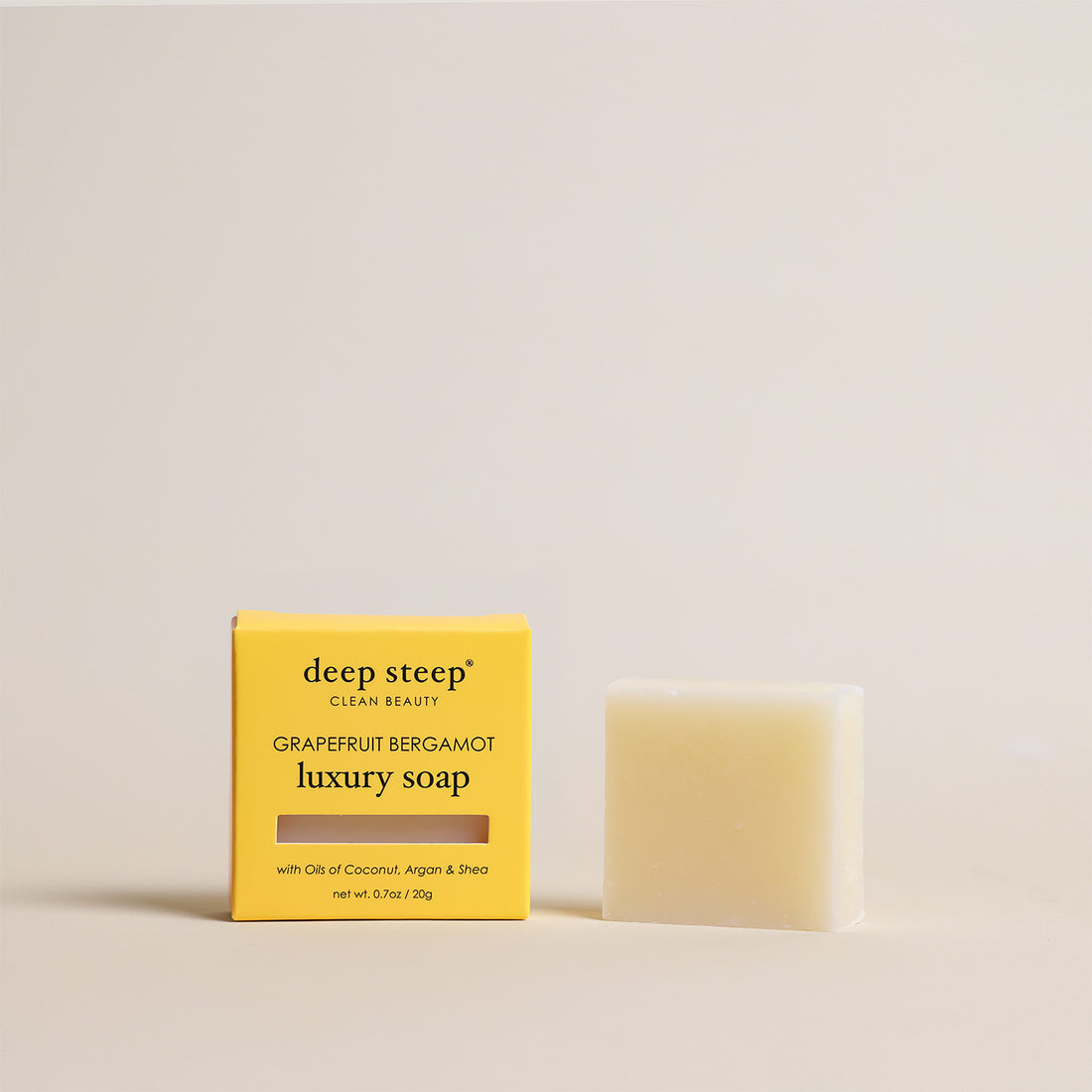 Deep Steep Grapefruit Bergamot luxury soap bar, 0.7 oz net weight, next to its packaging box made with coconut, argan, and shea oils