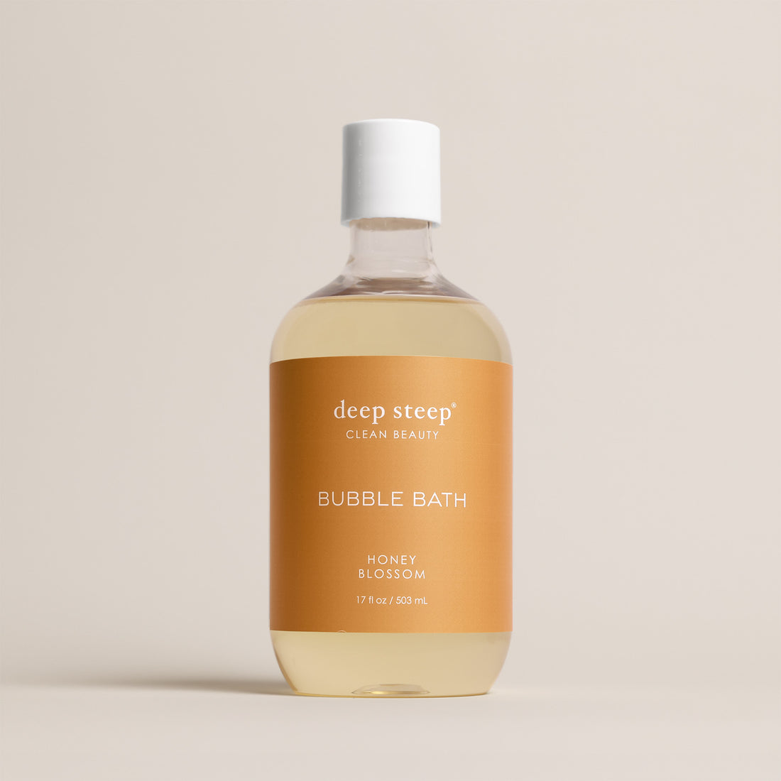 Deep Steep Honey Blossom Bubble Bath, 17 fl oz hypoallergenic bottle with a gold label on a neutral background