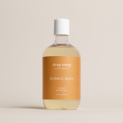 Deep Steep Honey Blossom Bubble Bath, 17 fl oz hypoallergenic bottle with a gold label on a neutral background