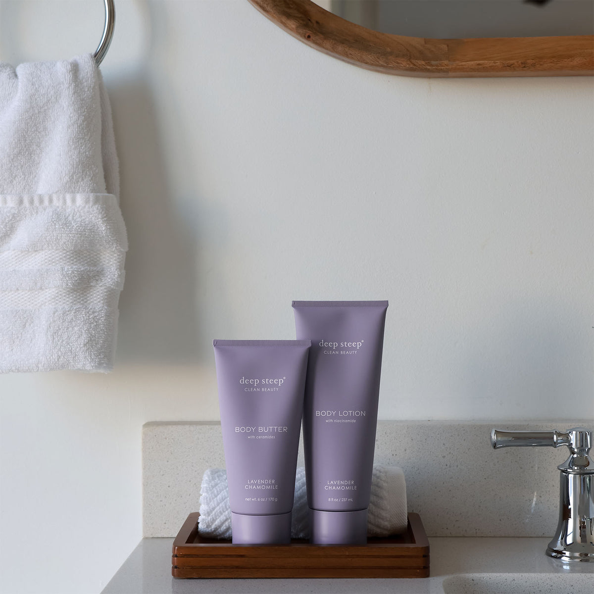 Two tubes of Deep Steep Lavender Chamomile body lotion and body butter on a wooden tray on a bathroom counter