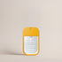 Front view of the Deep Steep Peach Bellini Hydrating Mist pocket sanitizer spray in a bright yellow-orange rectangular bottle with a clear front label against a solid beige background.