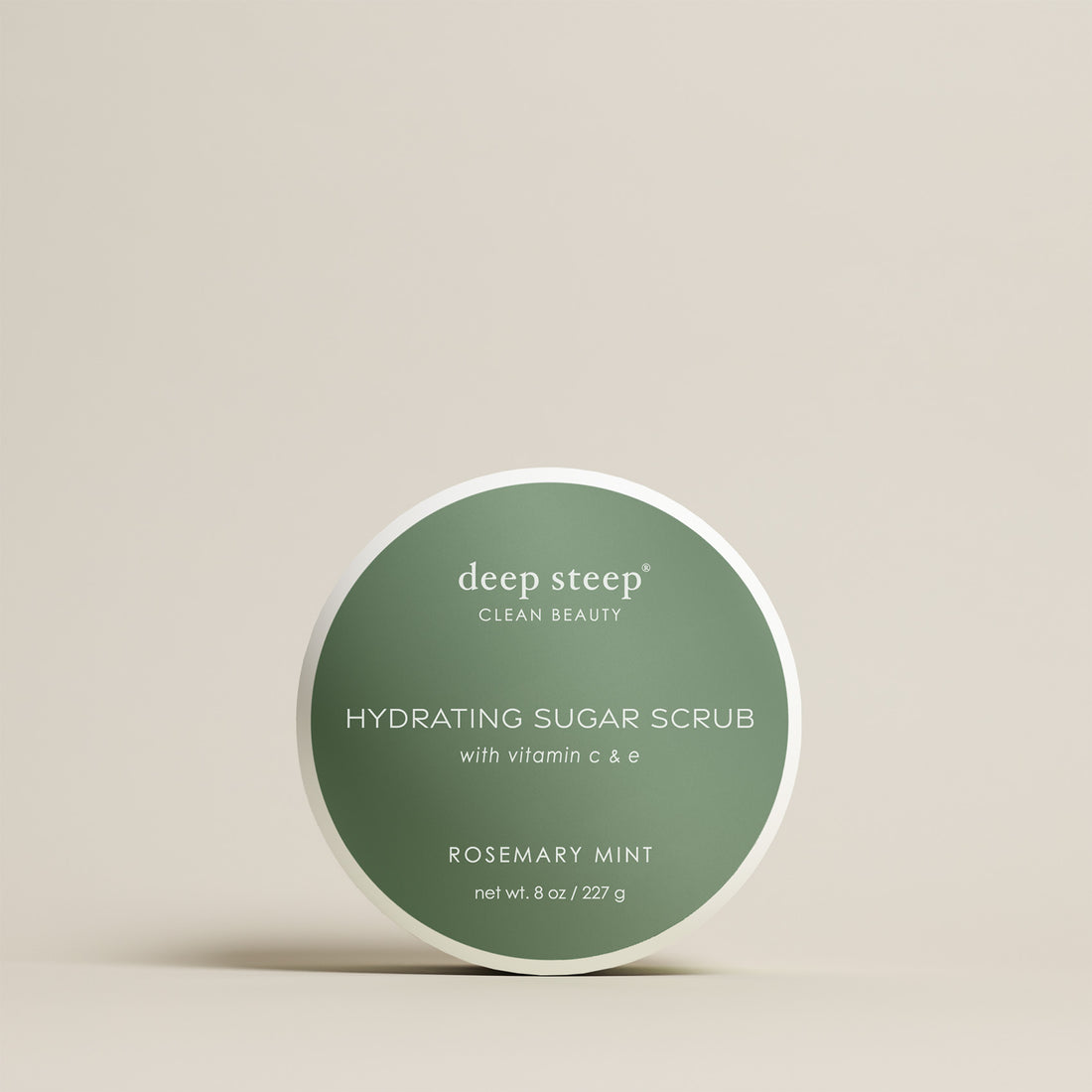 8 oz / 227 g Deep Steep Rosemary Mint hydrating sugar scrub with vitamin C and E in a container on a beige background