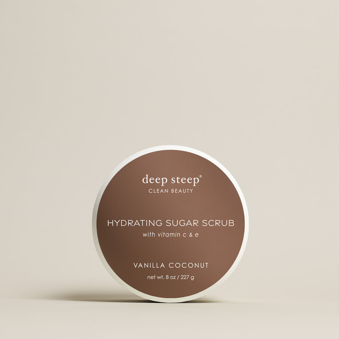 8 oz / 227 g Deep Steep Vanilla Coconut hydrating sugar scrub with vitamin C and E in a container on a beige background